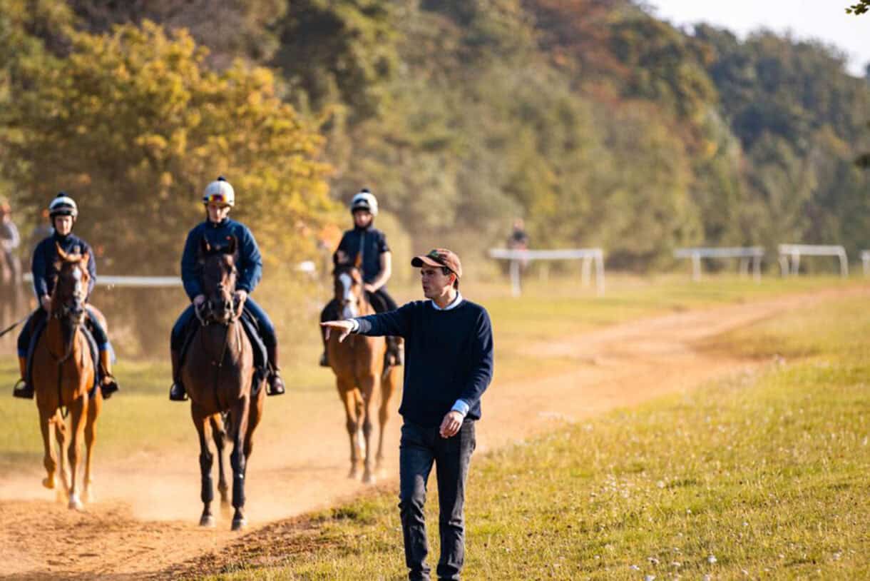 Racehorse trainer Tom Clover oversees his string returning from the gallops.