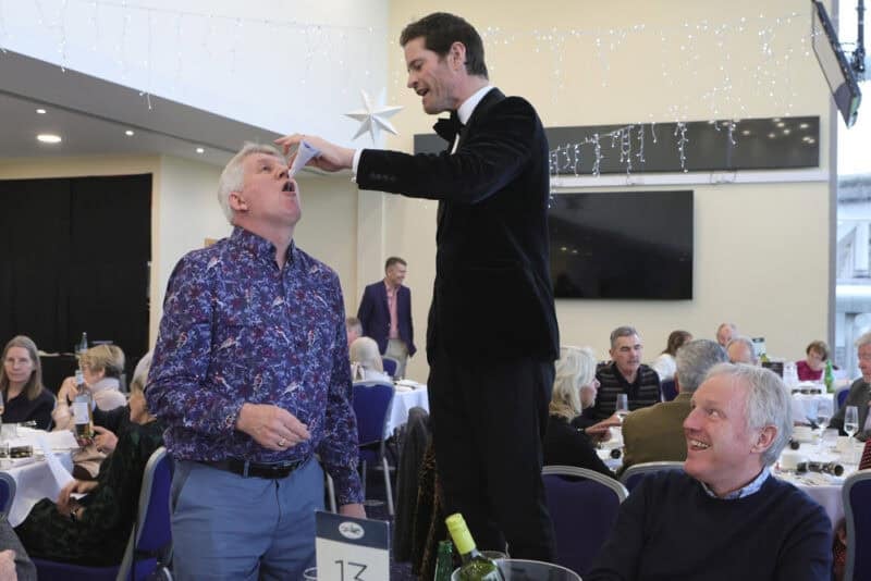 Magic tricks at a Christmas social lunch.