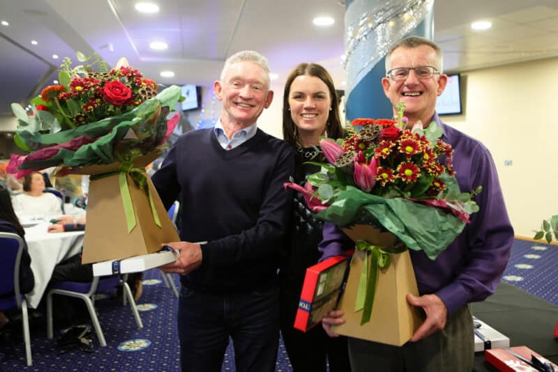Quiz winners collecting their prizes at a Christmas social event.