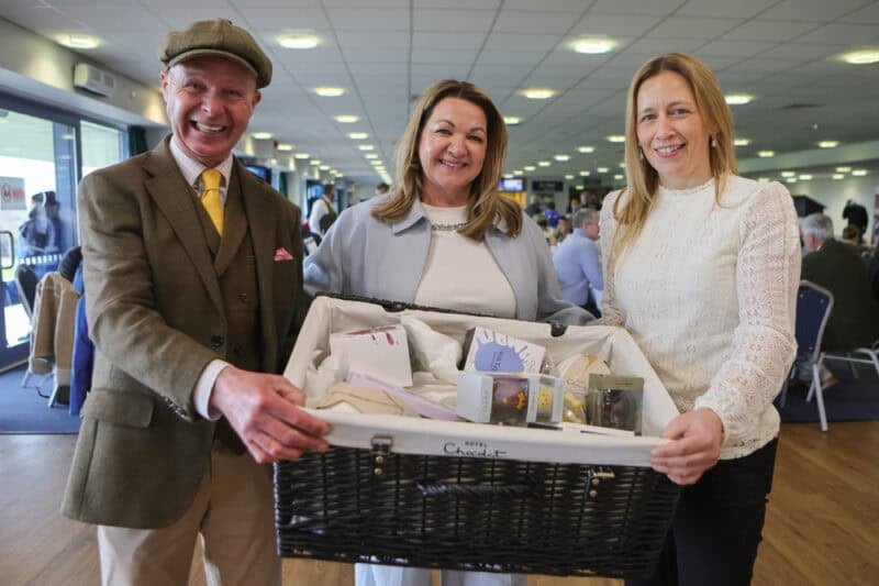 a lady receives a raffle prize from Luke Harvey at Doncaster