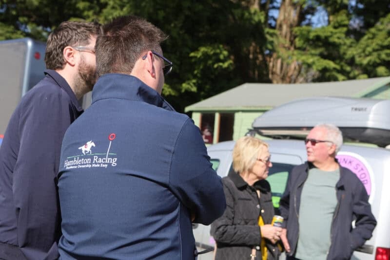 Hambleton Racing team members talking outdoors at event.