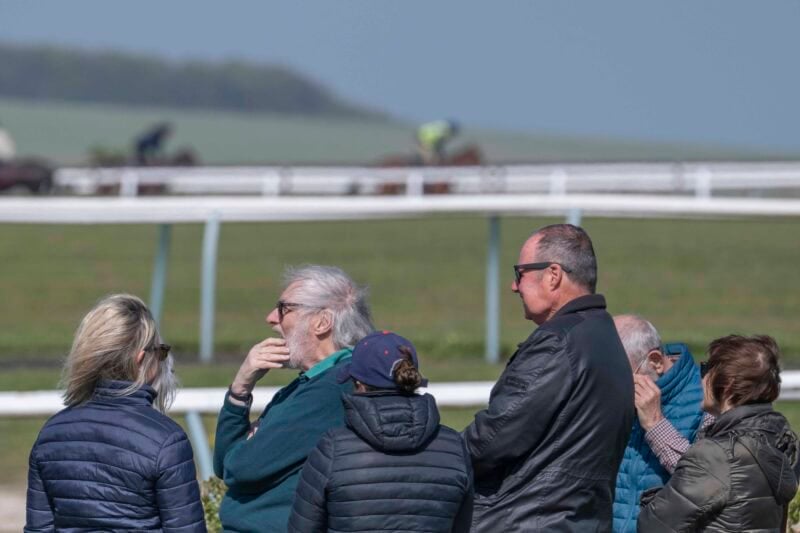 People watching horses exercise on Lambourn gallops.
